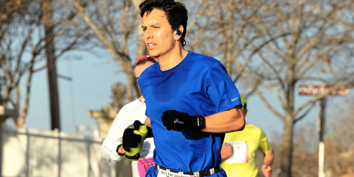 A man in blue t-shirt sweating while running. 