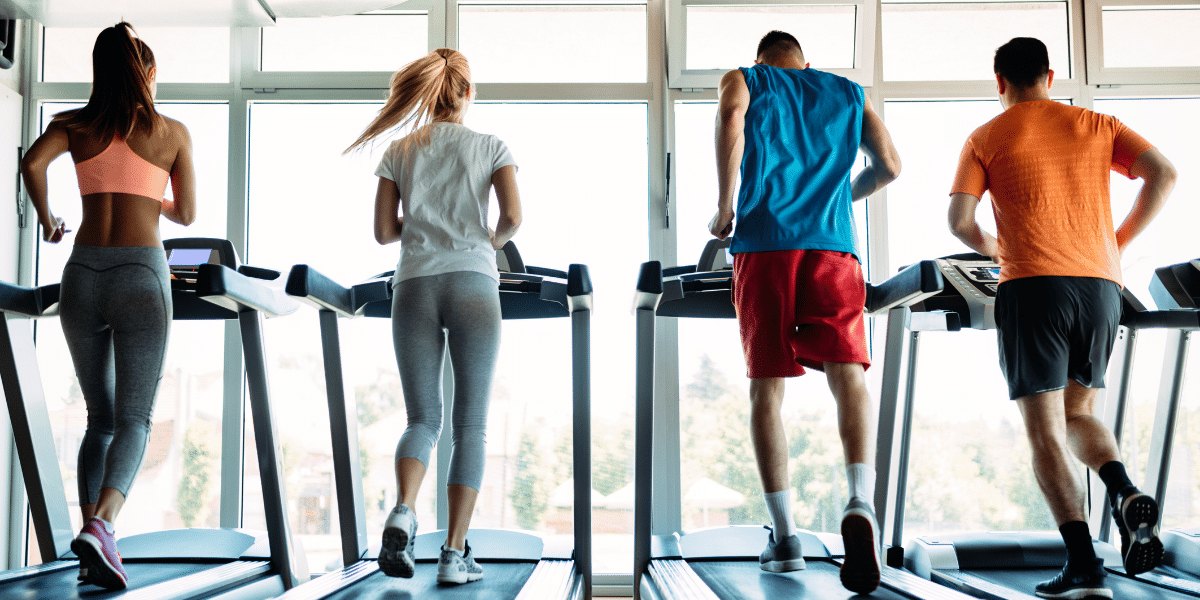 Group of people running on treadmill.